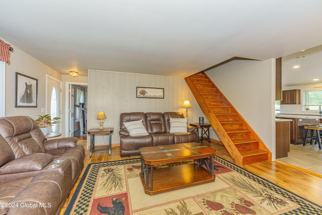 living room featuring wood-type flooring and wooden walls