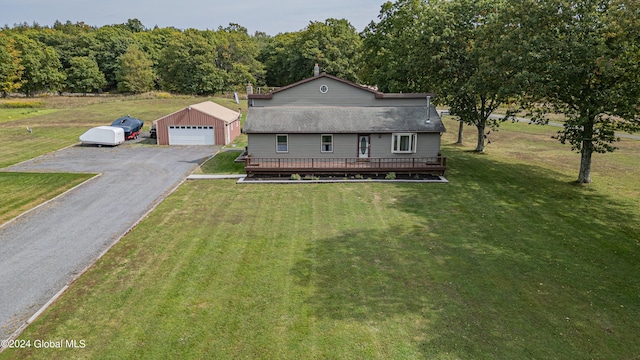 view of front of house featuring an outdoor structure, a garage, a wooden deck, and a front lawn