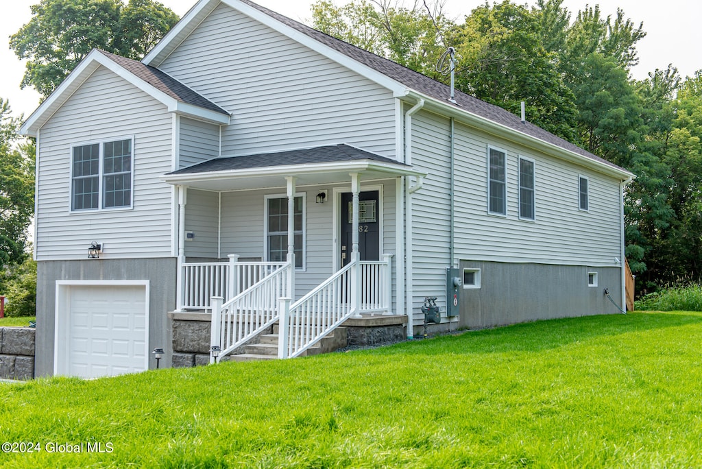 view of front of home featuring a porch, a garage, and a front lawn