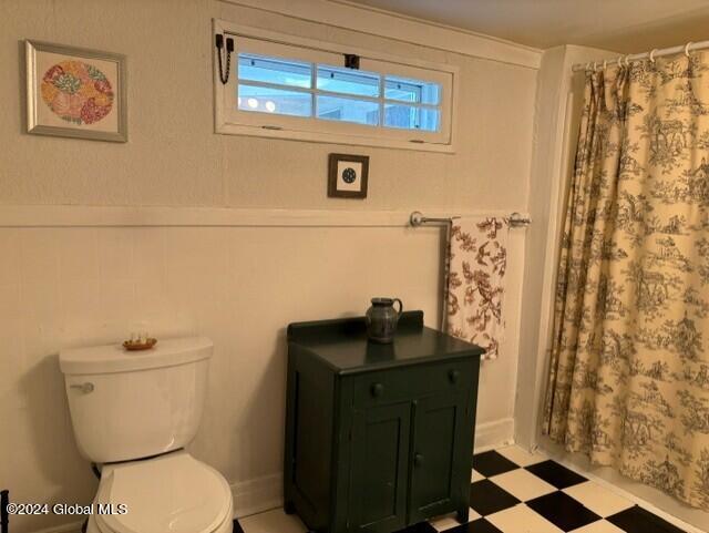 bathroom with toilet and curtained shower
