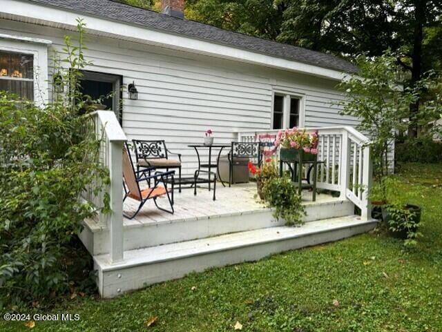 wooden deck featuring a lawn