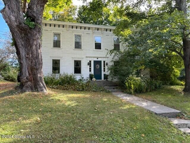 italianate home featuring a front lawn