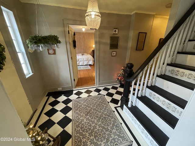 entryway featuring wooden walls, crown molding, and a notable chandelier