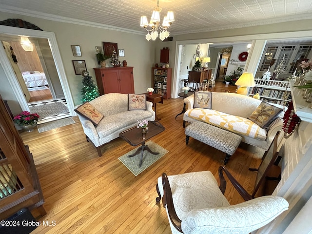 living room featuring a chandelier, light hardwood / wood-style floors, and ornamental molding