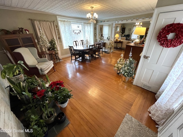 dining room featuring hardwood / wood-style floors, an inviting chandelier, and ornamental molding