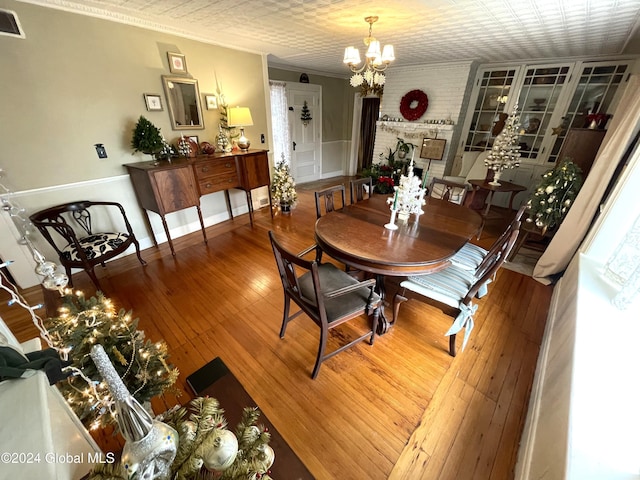 dining space with hardwood / wood-style flooring, an inviting chandelier, and crown molding