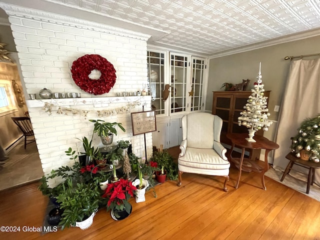 sitting room with hardwood / wood-style flooring and ornamental molding