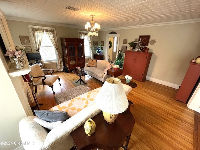 living room featuring light hardwood / wood-style floors, a chandelier, and ornamental molding