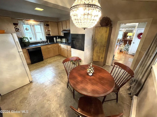 kitchen featuring dishwasher, light brown cabinetry, white refrigerator, and an inviting chandelier