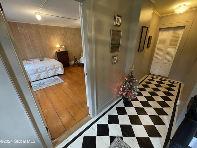 interior space with ornamental molding, a closet, and wooden walls