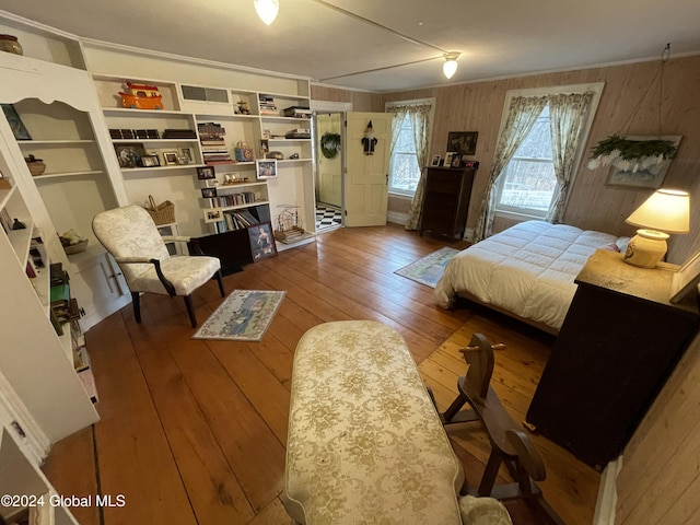 bedroom with hardwood / wood-style flooring and wood walls