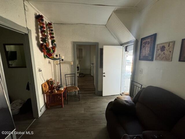 hallway with wood finished floors and lofted ceiling
