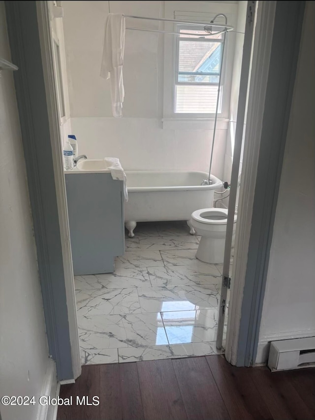 bathroom with vanity, baseboard heating, wood-type flooring, a tub, and toilet