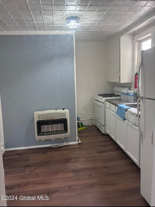 kitchen with heating unit, dark hardwood / wood-style flooring, white appliances, and white cabinetry