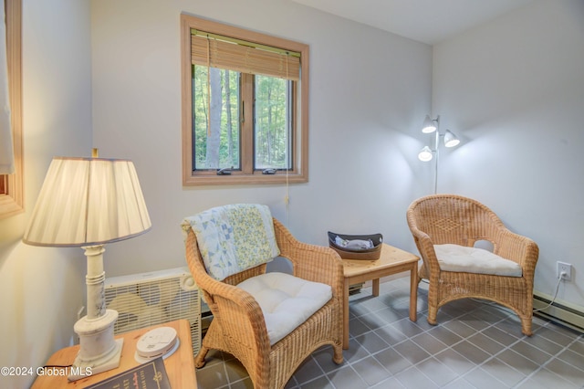 living area featuring a baseboard heating unit and dark tile patterned floors