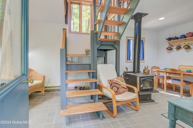 stairs featuring baseboard heating and a wood stove