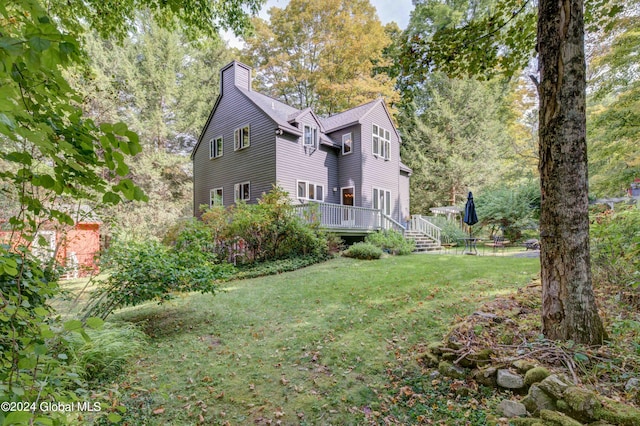 view of side of property featuring a wooden deck and a lawn