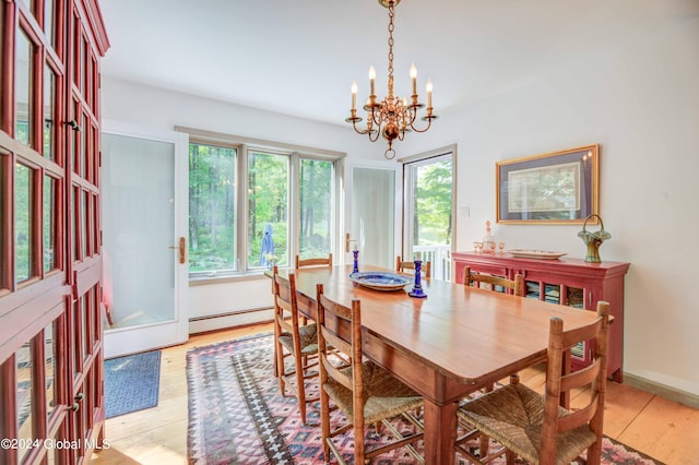 dining room with a notable chandelier, light wood-type flooring, and baseboard heating