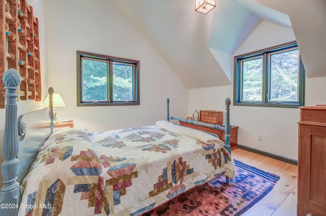 bedroom with lofted ceiling and light hardwood / wood-style floors