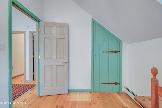 bonus room with wood-type flooring, lofted ceiling, and baseboard heating