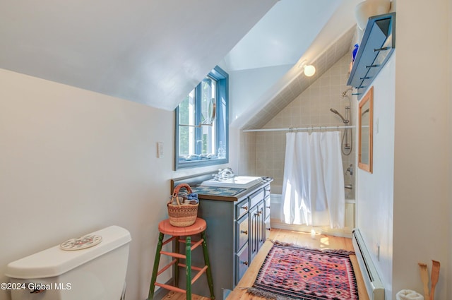 laundry area featuring a baseboard heating unit, hardwood / wood-style floors, and sink