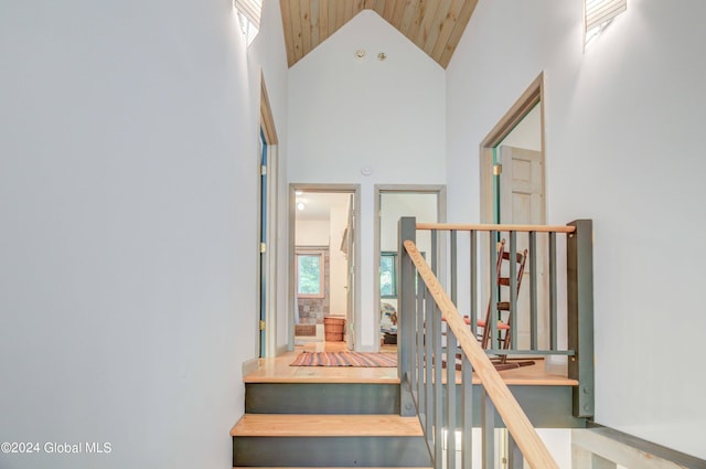 stairway featuring wooden ceiling and high vaulted ceiling