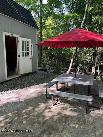 view of home's community featuring a patio area and an outdoor structure