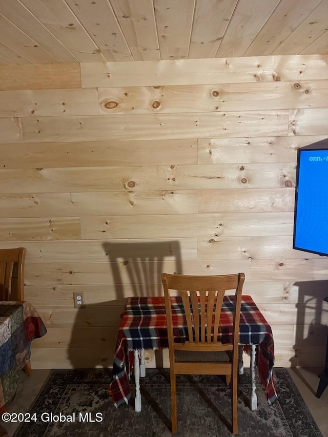 dining room with wood ceiling and wooden walls