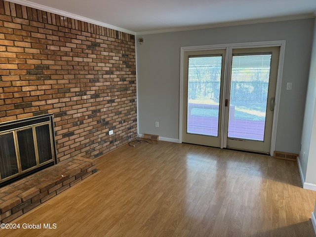 25 Kling Ter, Voorheesville, NY 12186 - unfurnished living room featuring brick wall, wood finished floors, baseboards, crown molding, and a fireplace