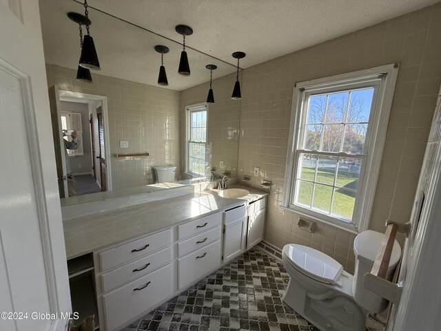 25 Kling Ter, Voorheesville, NY 12186 - bathroom with tile walls, toilet, vanity, and a textured ceiling