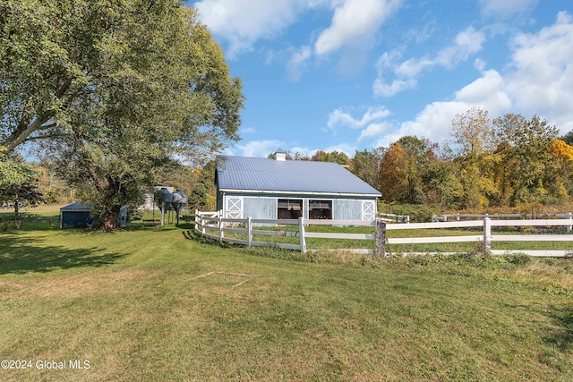 view of front of property featuring a rural view, an outbuilding, and a front yard