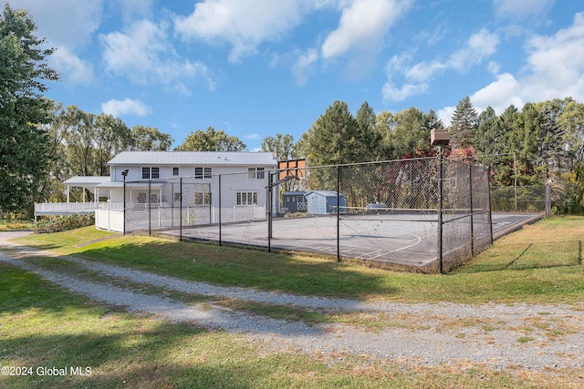 view of basketball court with a yard