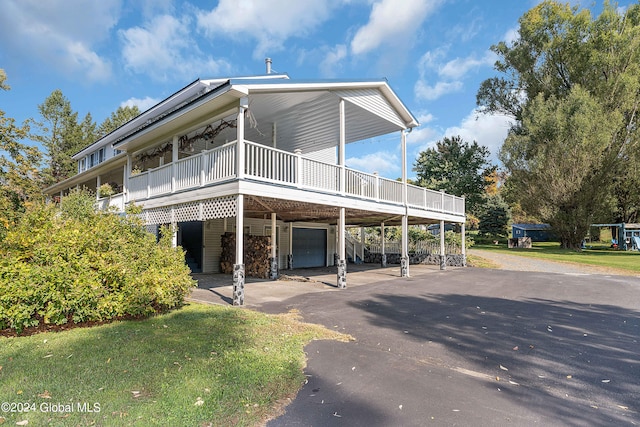 exterior space with a carport, a garage, and a yard