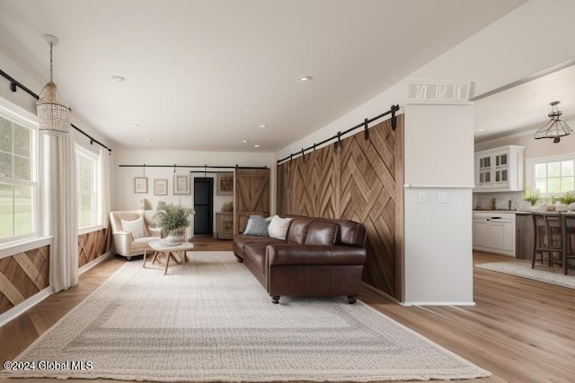 living room featuring a barn door and light hardwood / wood-style floors