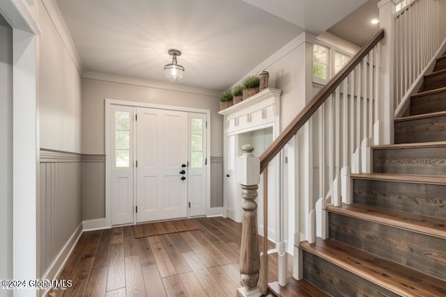 foyer featuring dark hardwood / wood-style floors and crown molding