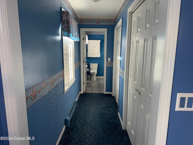 hall with dark colored carpet and baseboard heating