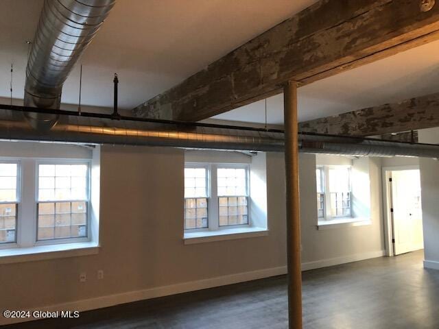 basement featuring dark wood-type flooring and a healthy amount of sunlight