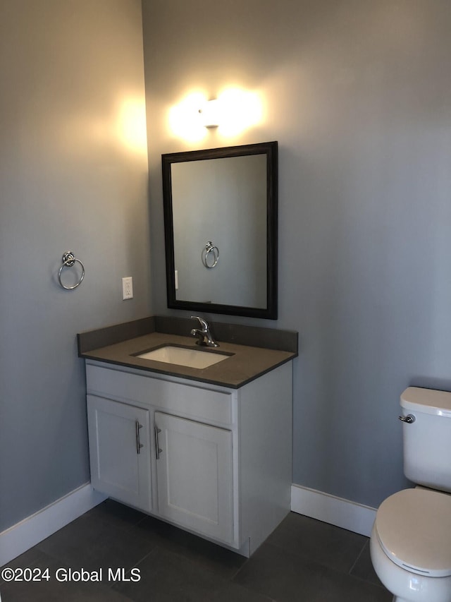 bathroom with tile patterned flooring, vanity, and toilet