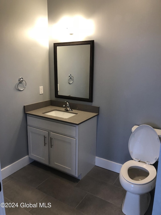 bathroom with tile patterned flooring, vanity, and toilet