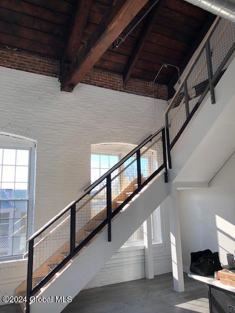 staircase with concrete flooring and wood ceiling