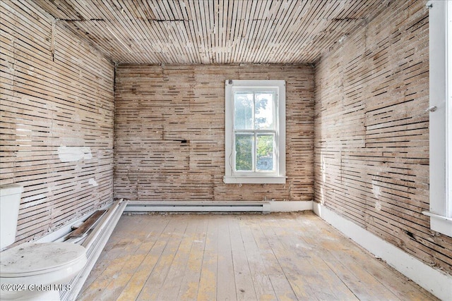 empty room featuring wood walls and hardwood / wood-style floors