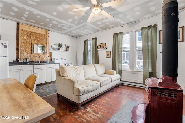 living room with ceiling fan, sink, baseboard heating, and dark hardwood / wood-style flooring