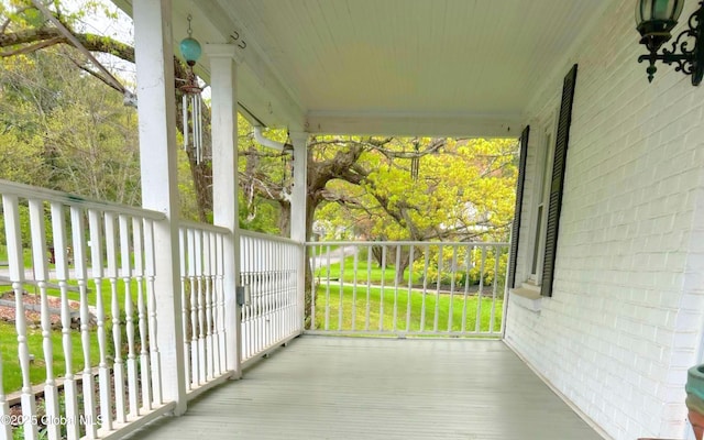 deck with a porch and a yard
