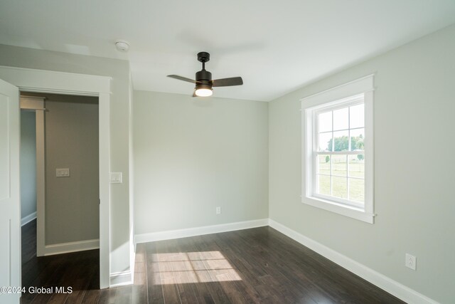 unfurnished room with ceiling fan and dark hardwood / wood-style flooring