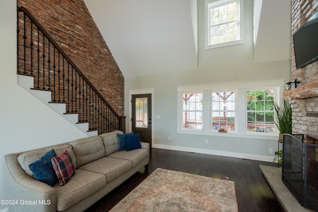 living room with dark wood-type flooring and high vaulted ceiling