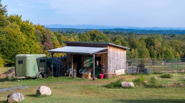 view of outdoor structure featuring a mountain view and a lawn