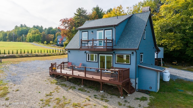 back of house featuring a wooden deck and a balcony