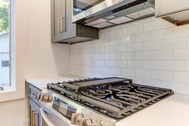 kitchen with decorative backsplash, stainless steel appliances, and gray cabinets