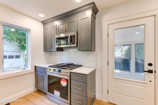 kitchen featuring stainless steel appliances, plenty of natural light, and gray cabinetry