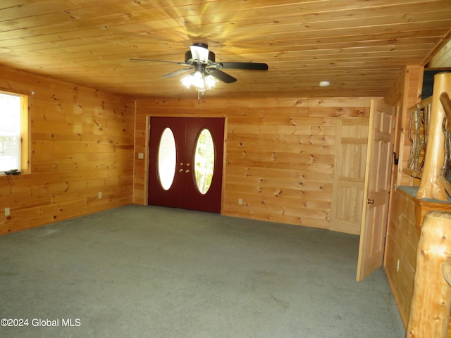 foyer with wood ceiling, wood walls, ceiling fan, and carpet floors